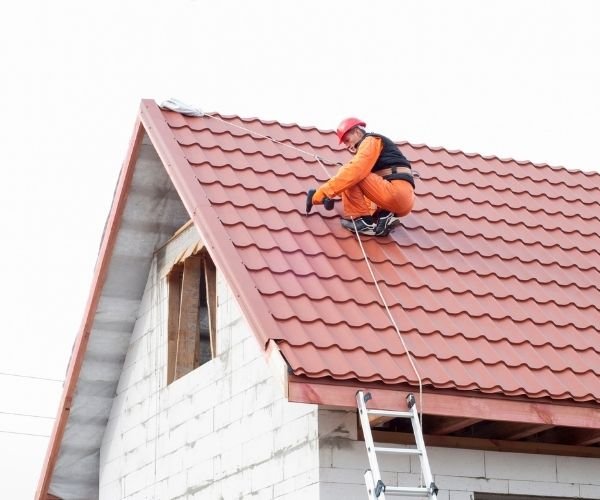 Dachdecker Rudolf – Techniker arbeitet auf einem roten Ziegeldach